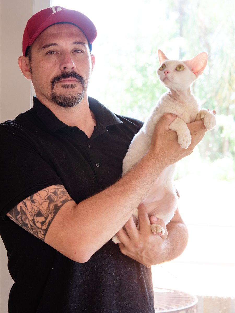 Rômulo Garcia, do Gatil Dartmoor, segurando um filhote de Devon Rex